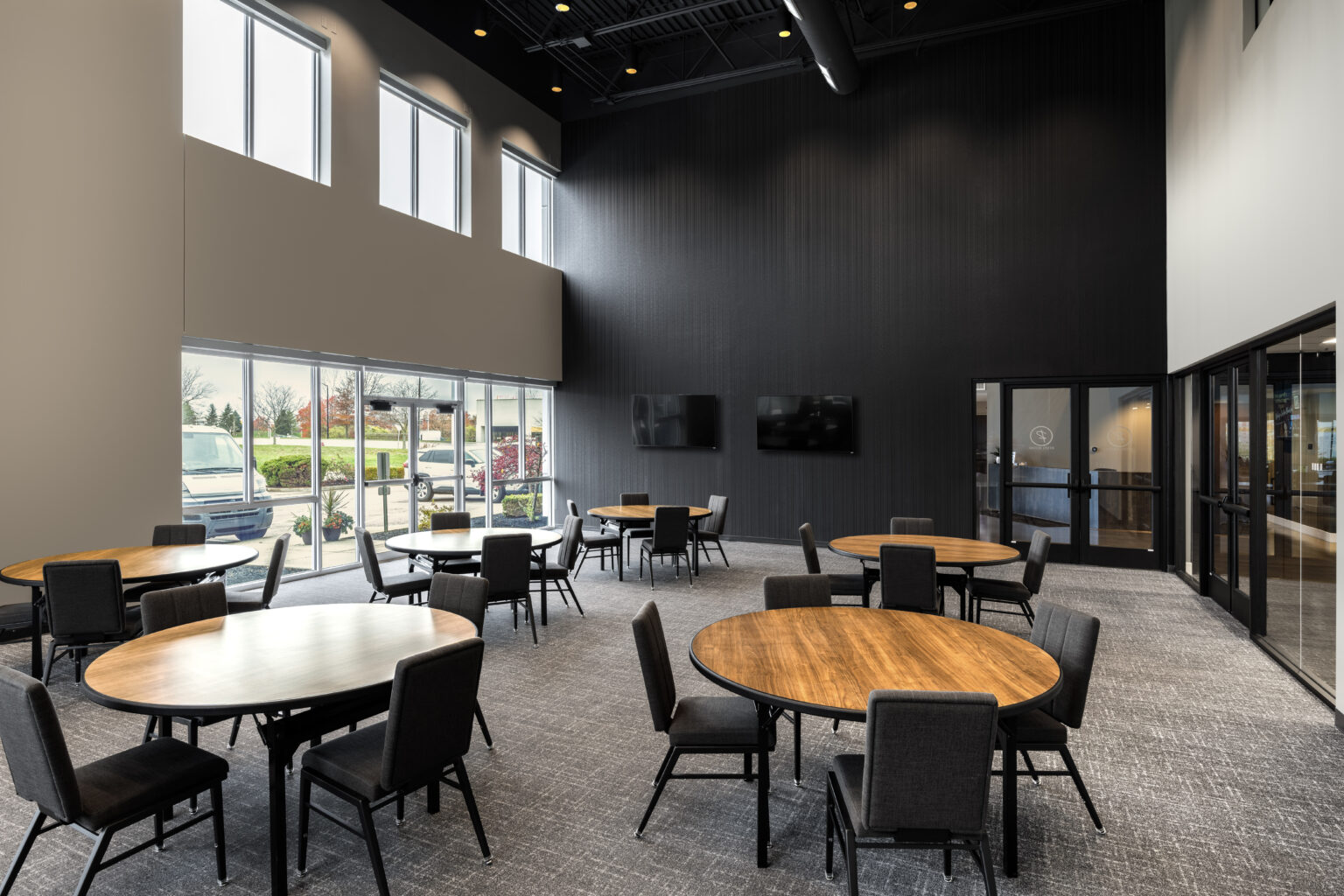 Dining room with round tables and tall windows at the Zink Cincinnati center