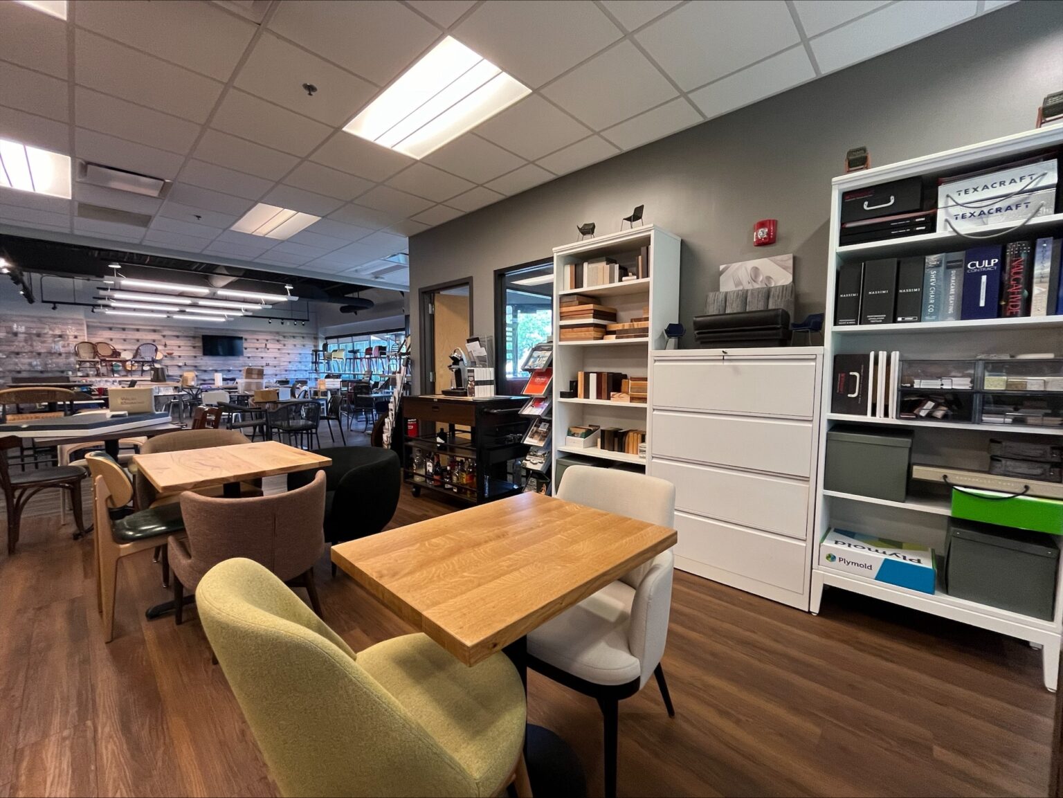 Design library with wood tables, lounge chairs, and sample shelves at the Zink Chicago Design Center in Lisle