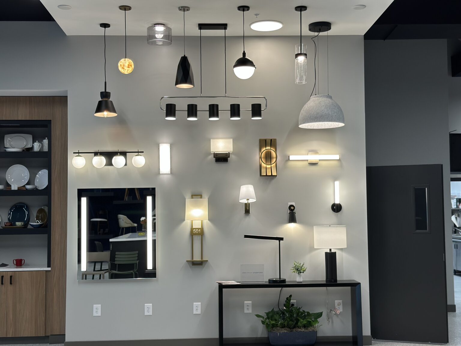 Lighting display wall with pendants, sconces, and lighted mirrors at the Columbus Design Center