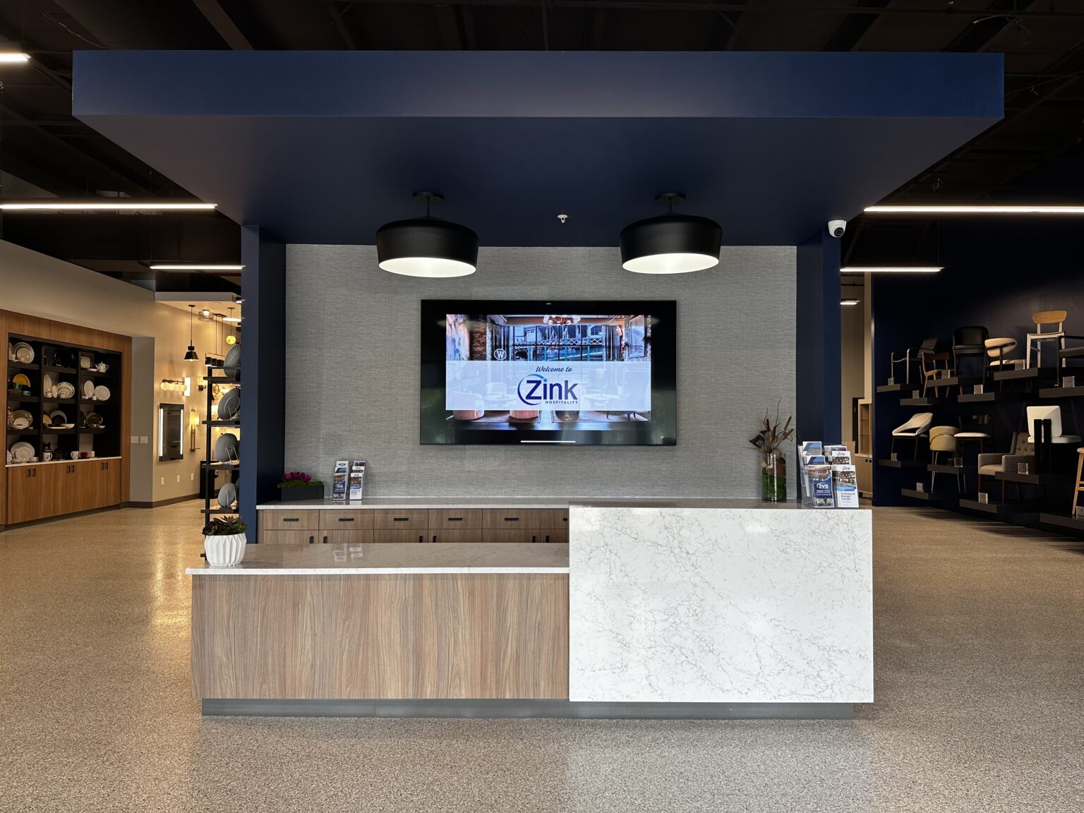 Front desk at the Zink Hospitality Columbus Design Center with a navy ceiling and pendant lights